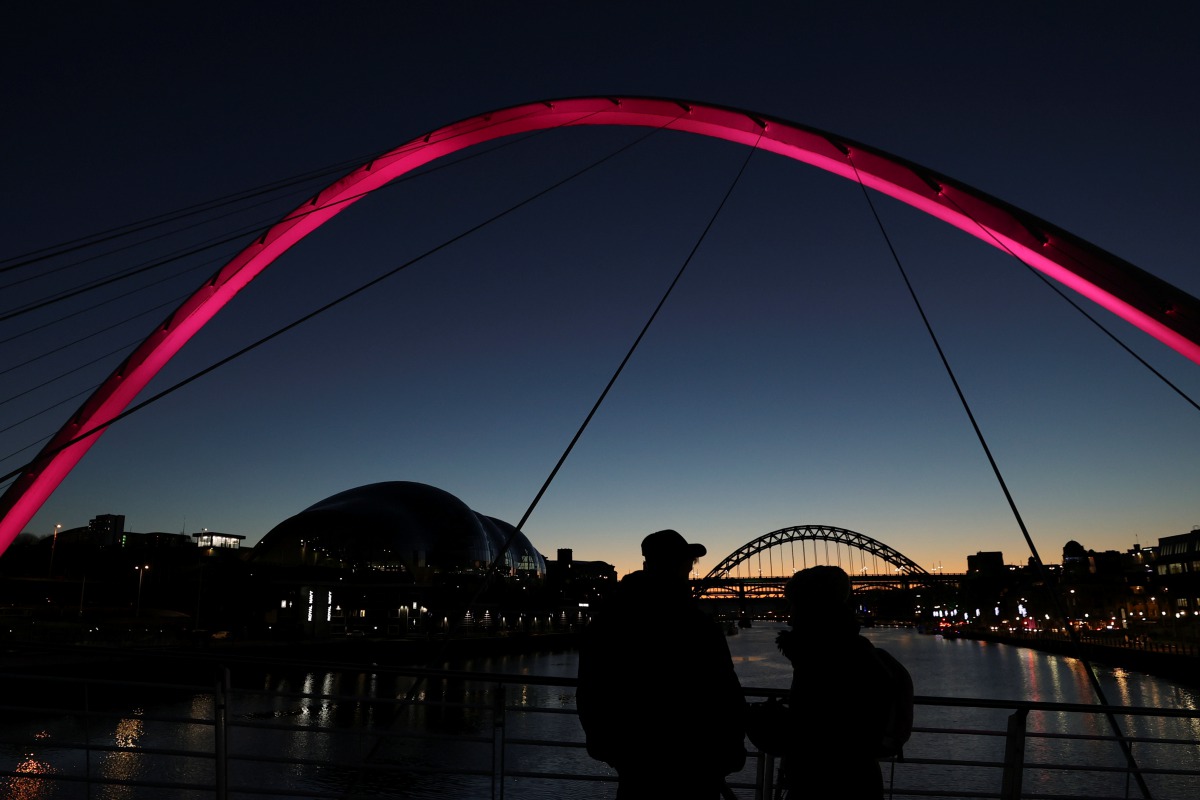 People watch the sunset ahead of the start of tier 4 restrictions as the coronavirus disease (COVID-19) outbreak continues, at Quayside in Newcastle, Britain December 30, 2020. REUTERS/Lee Smith
