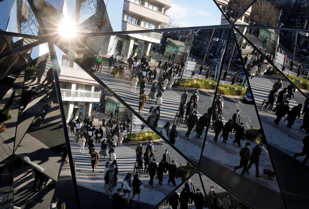 Year-end shoppers wearing protective face masks are reflected on mirrors at a shopping and amusement district, amid the coronavirus disease (COVID-19) outbreak, in Tokyo, Japan December 31, 2020. REUTERS/Issei Kato