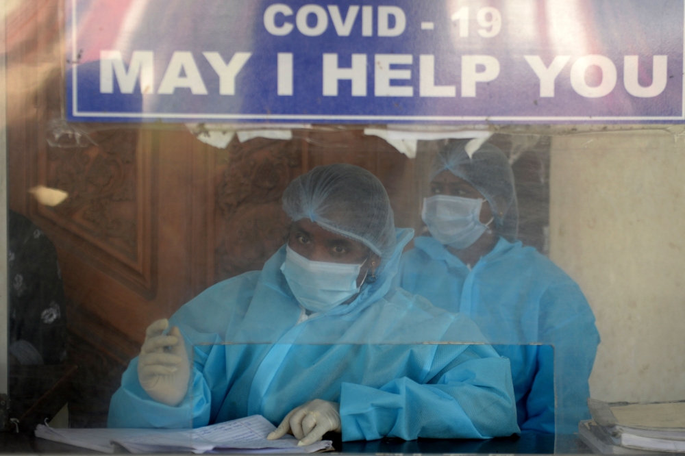 Medical staff wearing Personal protective equipment (PPE) suits work at a desk of a government hospital in Chennai on December 31, 2020. / AFP / Arun SANKAR