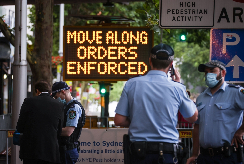 New South Wales police officers guard an entrance as part of Covid-19 restrictions for New Year celebrations around Circular Quay in central Sydney on December 31, 2020. AFP / DAVID GRAY