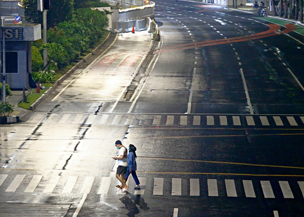 People walk during large-scale social restrictions to prevent the spread of coronavirus disease (COVID-19) on New Year's Eve in Jakarta, Indonesia, December 31, 2020. REUTERS/Ajeng Dinar Ulfiana