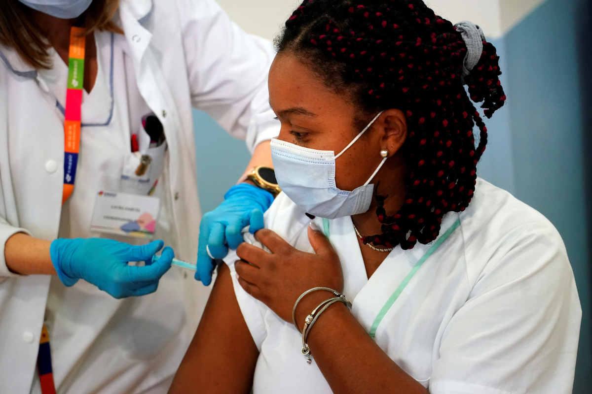 Jennifer Arce, worker of the Amavir nursing home, receives an injection with a dose of the Pfizer-BioNTech COVID-19 vaccine, as the coronavirus disease (COVID-19) outbreak continues, in Madrid, Spain, December 30, 2020. REUTERS/Juan Medina
