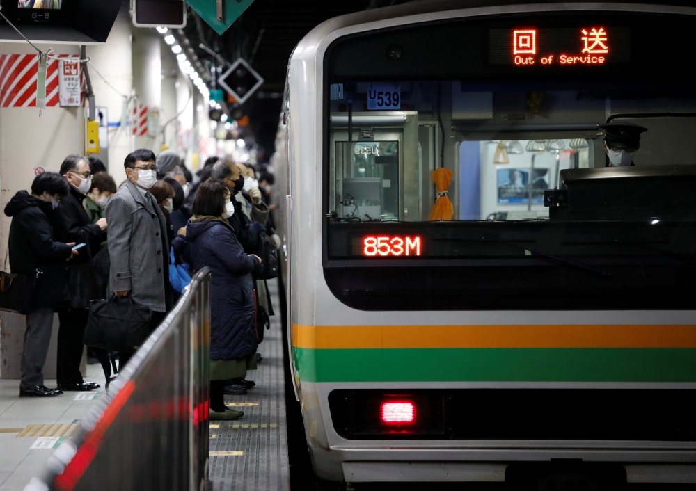 Commuters wearing protective face masks wait to enter a train on the way home, amid the coronavirus disease (COVID-19) outbreak, at a train station in Tokyo, Japan, January 5, 2021. Reuters/Issei Kato