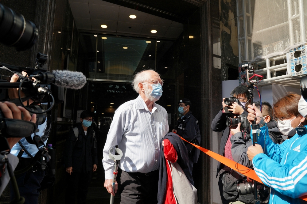 American lawyer John Clancey walks out of a building as he is taken away by police officers in Hong Kong, China January 6, 2021. Reuters/Lam Yik