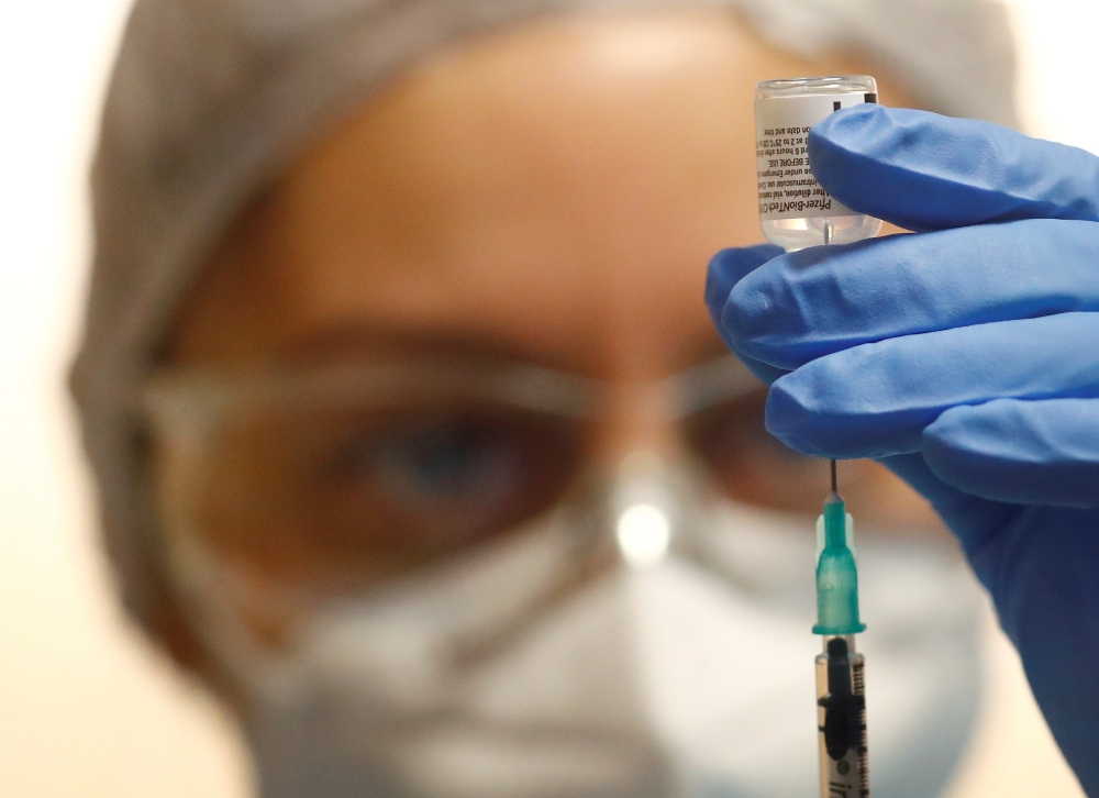 Oezlem Saki, member of a German Red Cross mobile vaccination team prepares the Pfizer-BioNTech COVID-19 vaccine. Reuters/Kai Pfaffenbach