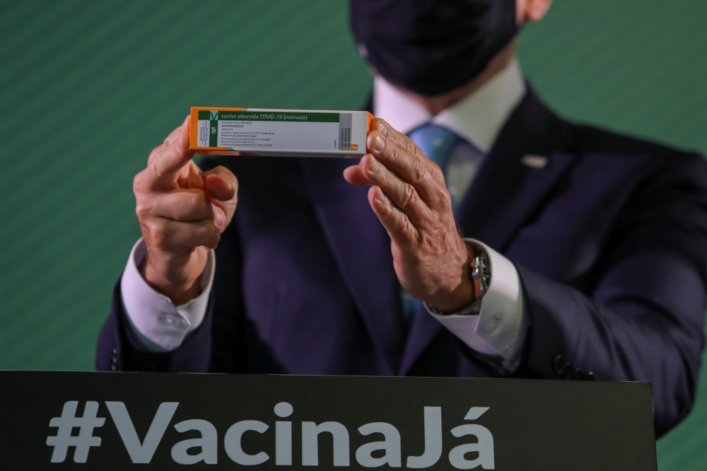 Brazil's Sao Paulo state governor Joao Doria holds a box of China's Sinovac coronavirus disease (COVID-19) vaccine during a news conference about its efficacy results at Instituto Butantan in Sao Paulo, Brazil January 7, 2021. REUTERS/Amanda Perobelli