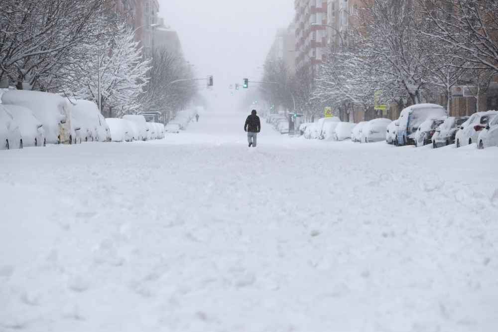 A person walks down the street during a heavy snowfall in Madrid, Spain, January 9, 2021. REUTERS/Sergio Perez