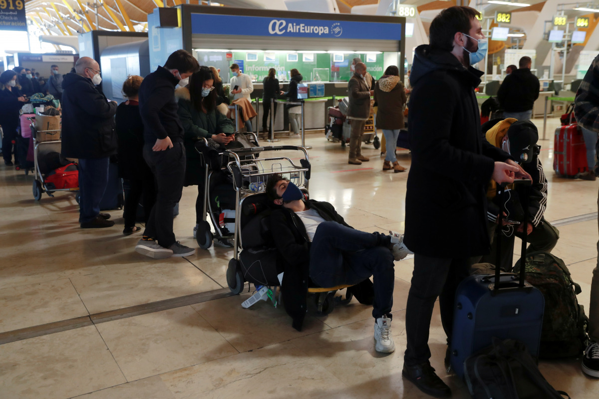 Stranded passengers wait for news about their flights at Adolfo Suarez Barajas airport, which is suspending flights due to heavy snowfall in Madrid, Spain, January 9, 2021. REUTERS/Susana Vera
