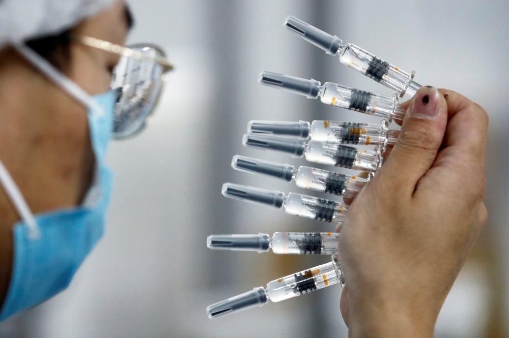 A worker performs a quality check in the packaging facility of Chinese vaccine maker Sinovac Biotech, developing an experimental coronavirus disease (COVID-19) vaccine, during a government-organized media tour in Beijing, China, September 24, 2020. REUTER