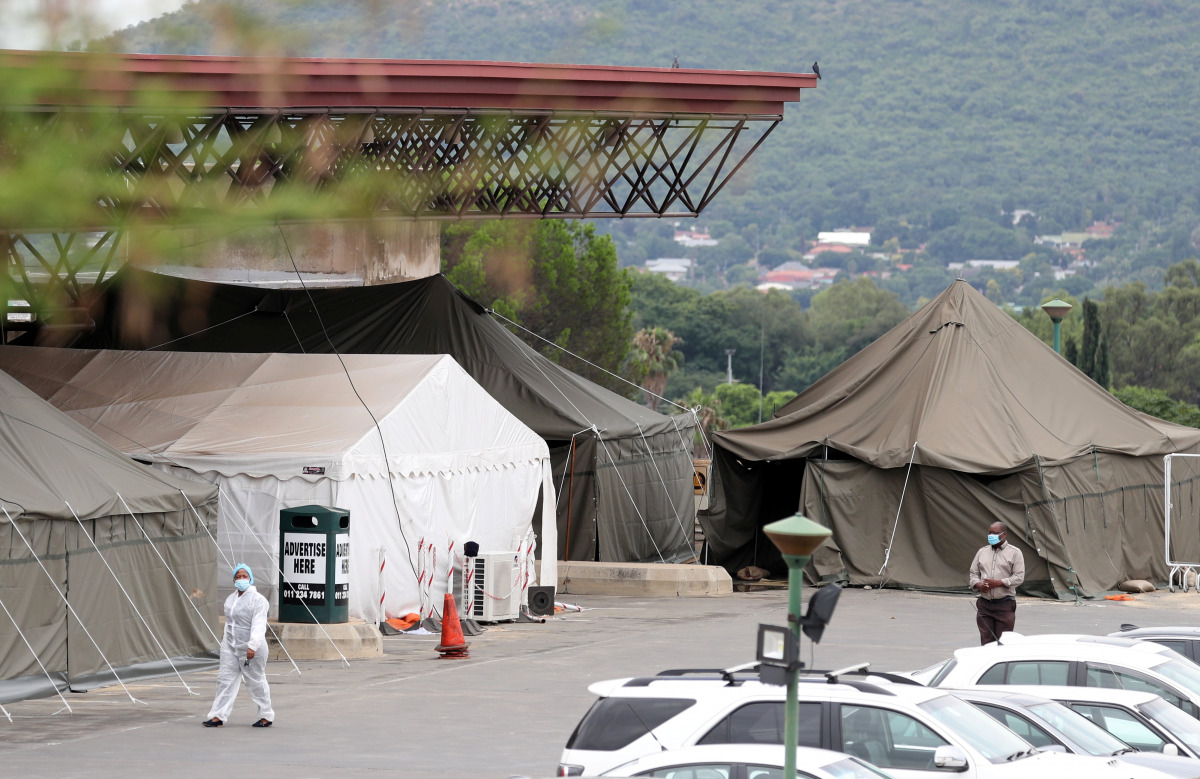A health worker walks past tents erected at the parking lot of the Steve Biko Academic Hospital, amid a nationwide coronavirus disease (COVID-19) lockdown, in PRETORIA, South Africa, January 11, 2021. REUTERS/Siphiwe Sibeko
