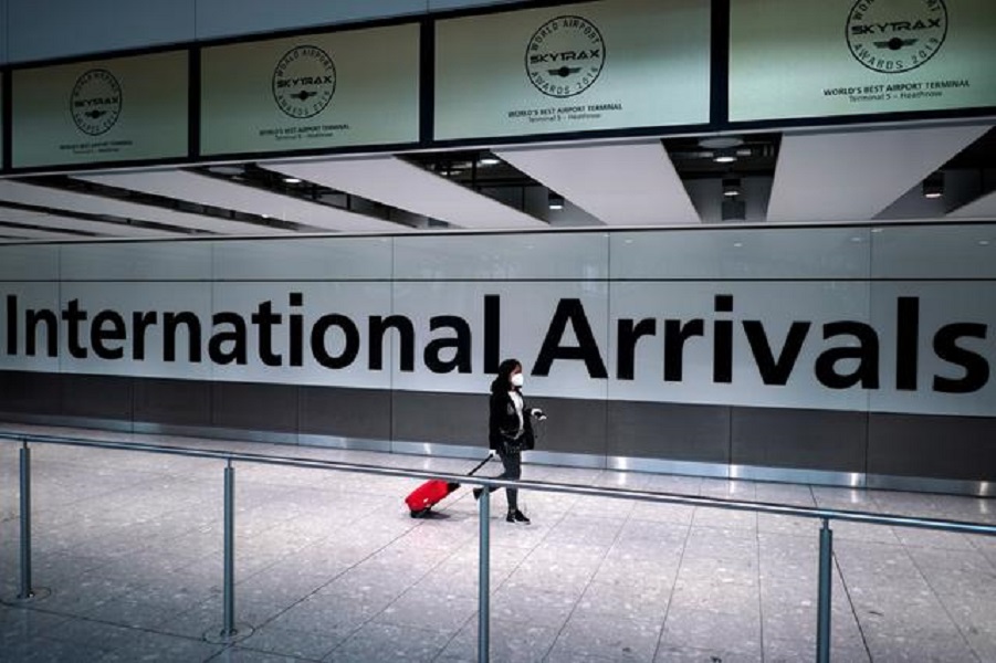 FILE PHOTO: A traveller wearing a face mask walks at the Terminal 5 at Heathrow Airport, as the spread of the coronavirus disease (COVID-19) continues, in London, Britain, July 26, 2020. REUTERS/Henry Nicholls
