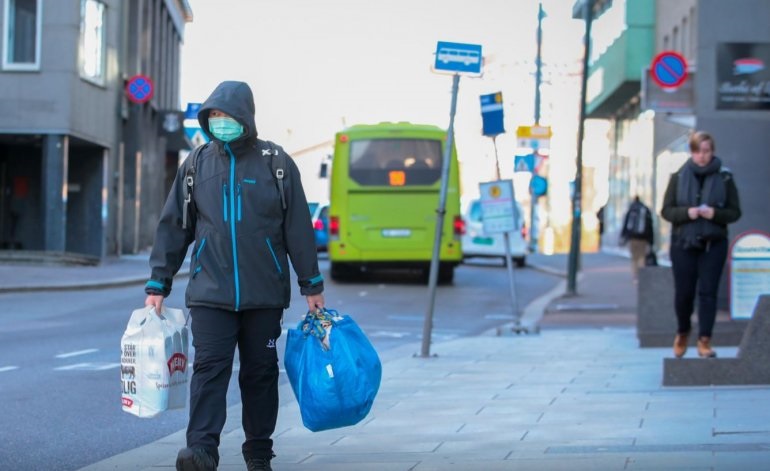 FILE PHOTO: A man wearing a protective mask carries shopping bags as he walks on the streets of Oslo following an outbreak of the coronavirus disease (COVID-19), in Oslo, Norway March 13, 2020. NTB Scanpix/Hakon Mosvold Larsen via REUTERS .
