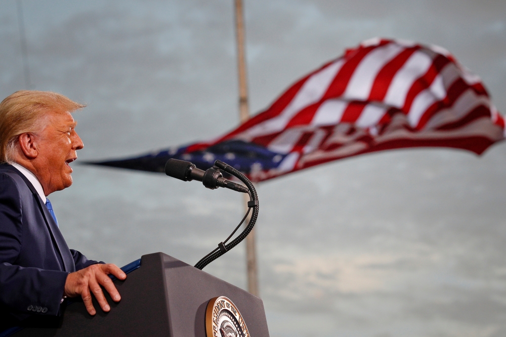 President Donald Trump speaks, with a flag behind him, during a campaign rally at Cecil Airport in Jacksonville, Florida, September 24, 2020. REUTERS/Tom Brenner/File Photo/File Photo