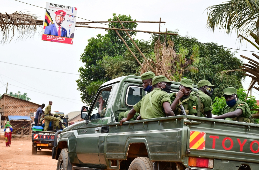 Ugandan security officers ride on their pickup truck as they patrol an area near the house of the presidential candidate and singer Robert Kyagulanyi Ssentamu, known as Bobi Wine in Magere neighbourhood of Kampala, Uganda January 16, 2021. REUTERS/Abubake