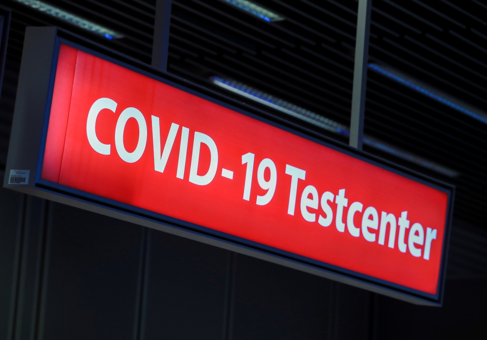 FILE PHOTO: A COVID-19 testing centre sign is pictured at Duesseldorf Airport in Duesseldorf, Germany, December 21, 2020. REUTERS/Wolfgang Rattay