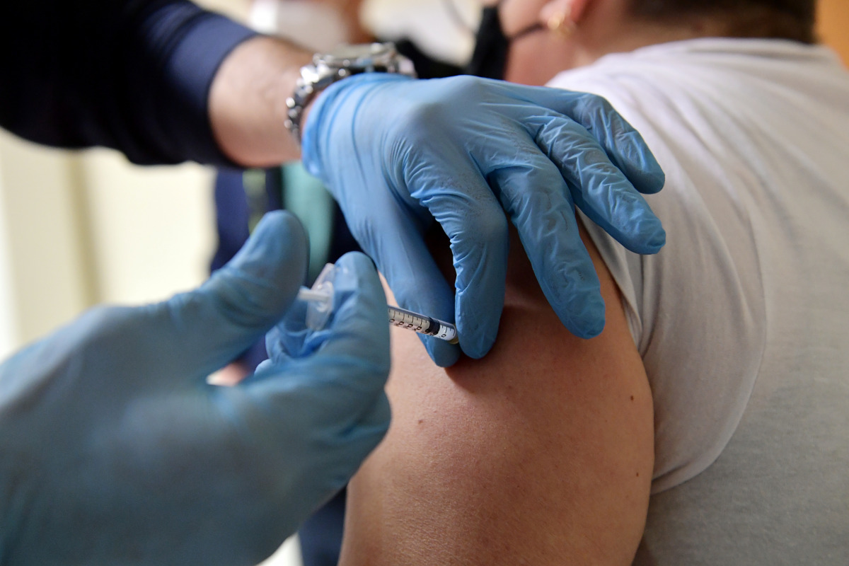 A volunteer who assists medical workers receives a dose of the Moderna coronavirus disease (COVID-19) vaccine at the Misericordia hospital in Grosseto, Italy, January 18, 2021. REUTERS/Jennifer Lorenzini
