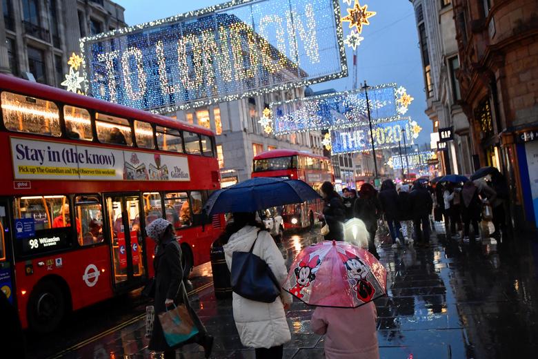FILE PHOTO: People hold umbrellas as they walk, following the outbreak of the coronavirus disease (COVID-19), in London, Britain December 16, 2020. REUTERS/Toby Melville


