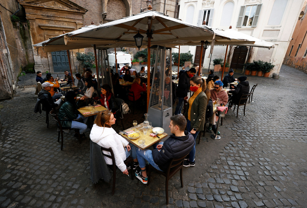 People sit at a restaurant in Trastevere after the coronavirus disease (COVID-19) restrictions were eased in Lazio region, Rome, Italy, February 1, 2021. REUTERS/Guglielmo Mangiapane
