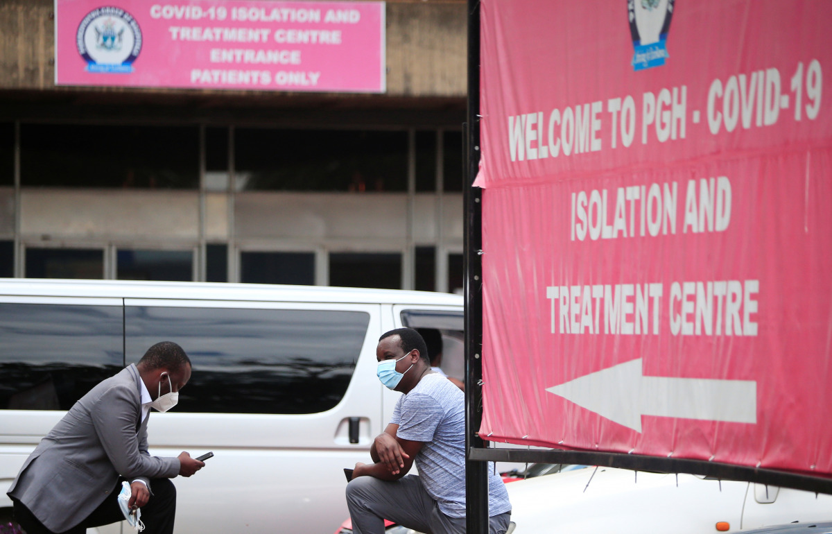 People sit beside banners outside a hospital during the coronavirus disease (COVID-19) outbreak in Harare, Zimbabwe January 28, 2021. Picture taken January 28, 2021. REUTERS/Philimon Bulawayo
