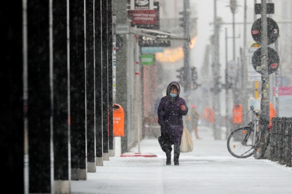 A person walks on a street during a snowfall in Berlin, Germany, February 7, 2021. REUTERS/Hannibal Hanschke