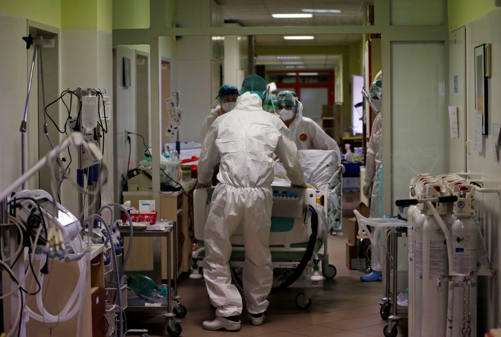 Members of the medical staff transfer a patient suffering from coronavirus disease (COVID-19) from a fully occupied Intensive Care Unit (ICU) of the Nachod hospital, Czech Republic February 11, 2021. Picture taken February 11, 2021. REUTERS/David W Cerny