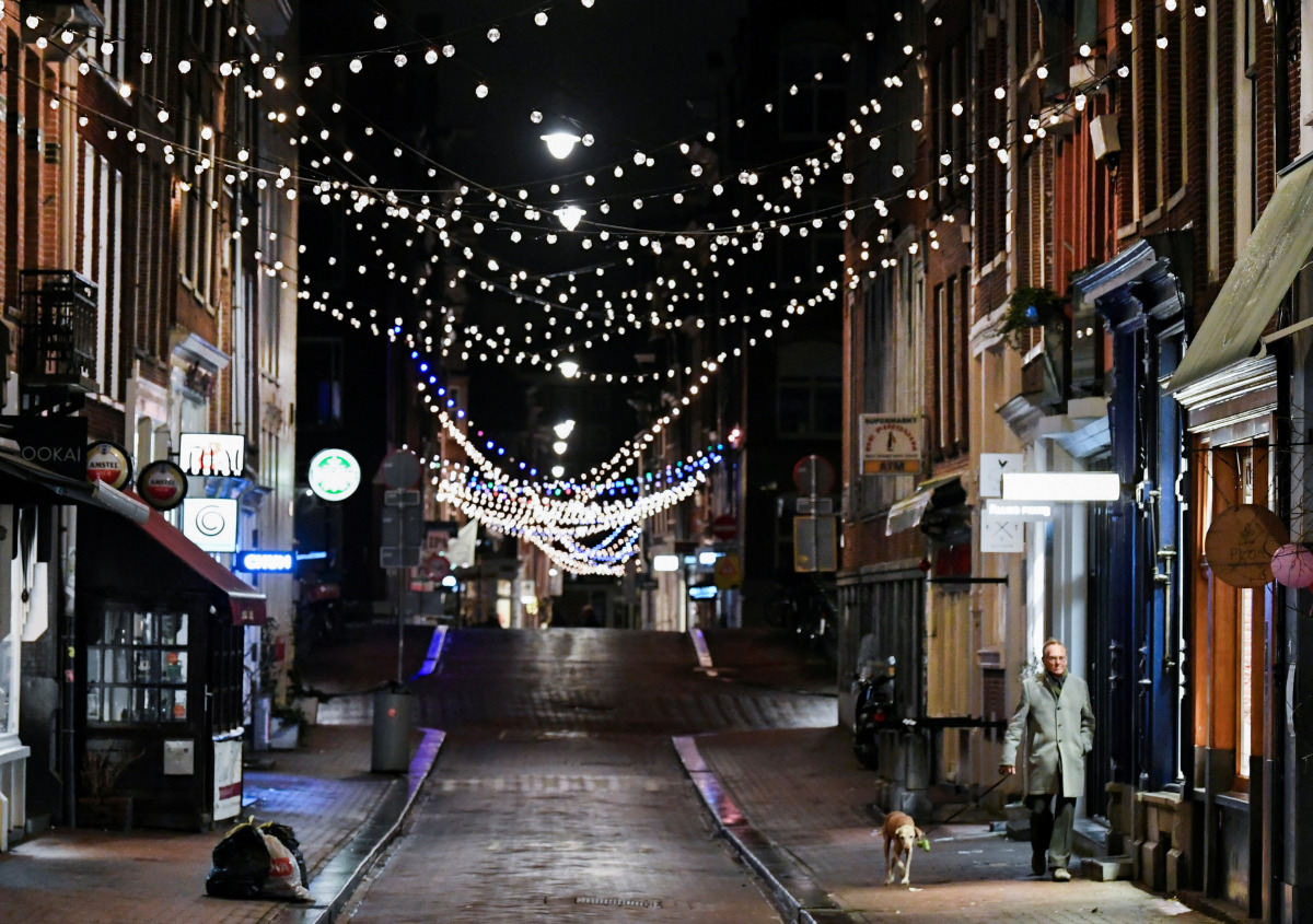 A man walks a dog after appellate judges ruled that a night-time curfew would remain in place in the Netherlands, pending a government appeal of a lower-court ruling that found the measure lacked legal justification, amid the coronavirus disease (COVID-19