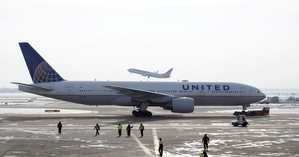 FILE PHOTO: A United Airlines Boeing 777-200ER plane is towed as an American Airlines Boeing 737 plane departs from O'Hare International Airport in Chicago, Illinois, U.S. Nov. 30, 2018. REUTERS/Kamil Krzaczynski/File Photo

