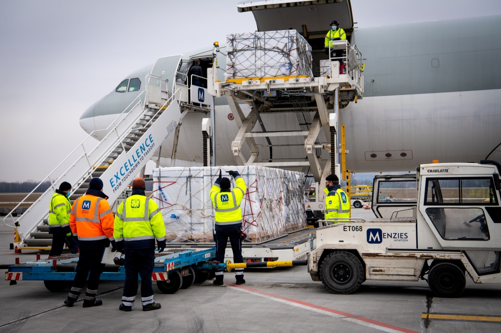 Workers unload a shipment of Chinese company Sinopharm's coronavirus disease (COVID-19) vaccine as it arrives at Budapest Airport, Hungary, February 16, 2021. Ministry of Foreign Affairs and Trade (KKM)/Handout via Reuters