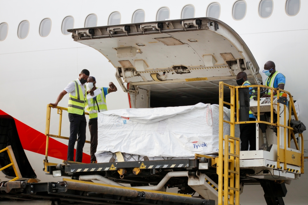 Workers offload boxes of AstraZeneca/Oxford vaccines as the country receives its first batch of coronavirus disease (COVID-19) vaccines under COVAX scheme, at the international airtport of Accra, Ghana February 24, 2021. Reuters/Francis Kokoroko