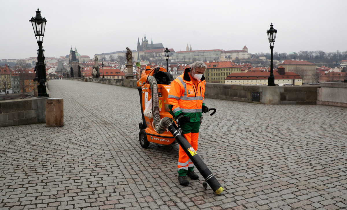 : A man wearing a face mask cleans the empty Charles Bridge as the Czech government-mandated further restrictions to curb the spread of the coronavirus disease (COVID-19) in Prague, Czech Republic, March 1, 2021. REUTERS/David W Cerny
