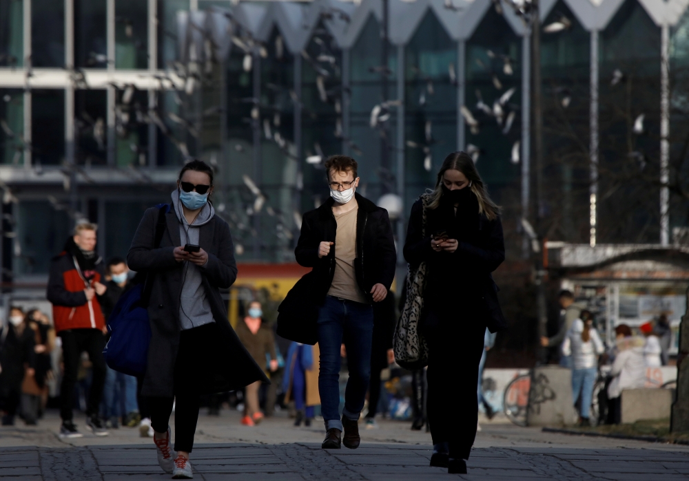 People wearing protective masks amid the outbreak of coronavirus disease (COVID-19) walk in the centre of Warsaw, Poland February 24, 2021. REUTERS/Kacper Pempel/File Photo