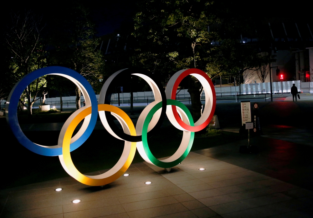 The Olympic rings are illuminated in front of the National Stadium in Tokyo, Japan January 22, 2021. REUTERS/Kim Kyung-Hoon//File Photo