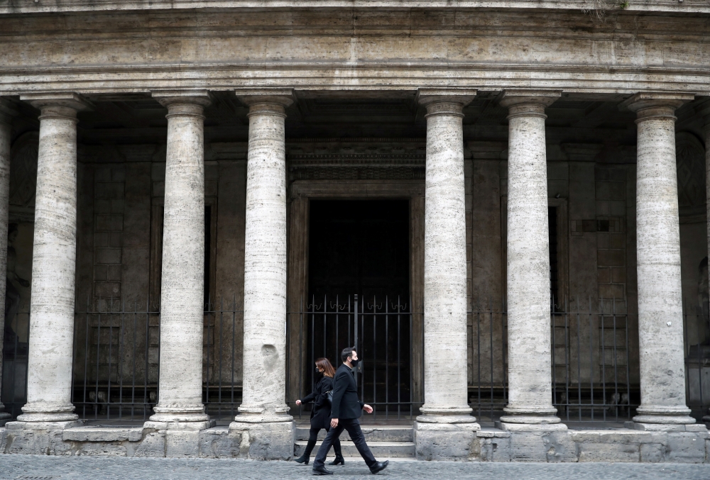 People walk in the street as the government is due to announce stricter coronavirus disease (COVID-19) restrictions, in Rome, Italy, March 12, 2021. REUTERS/Yara Nardi