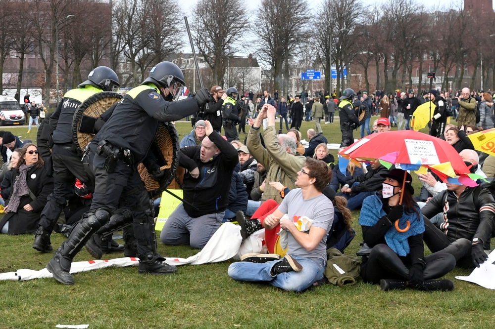 Police clash with demonstrators during a protest against coronavirus disease (COVID-19) restrictions in THE HAGUE, Netherlands, March 14, 2021. REUTERS/Piroschka Van De Wouw

