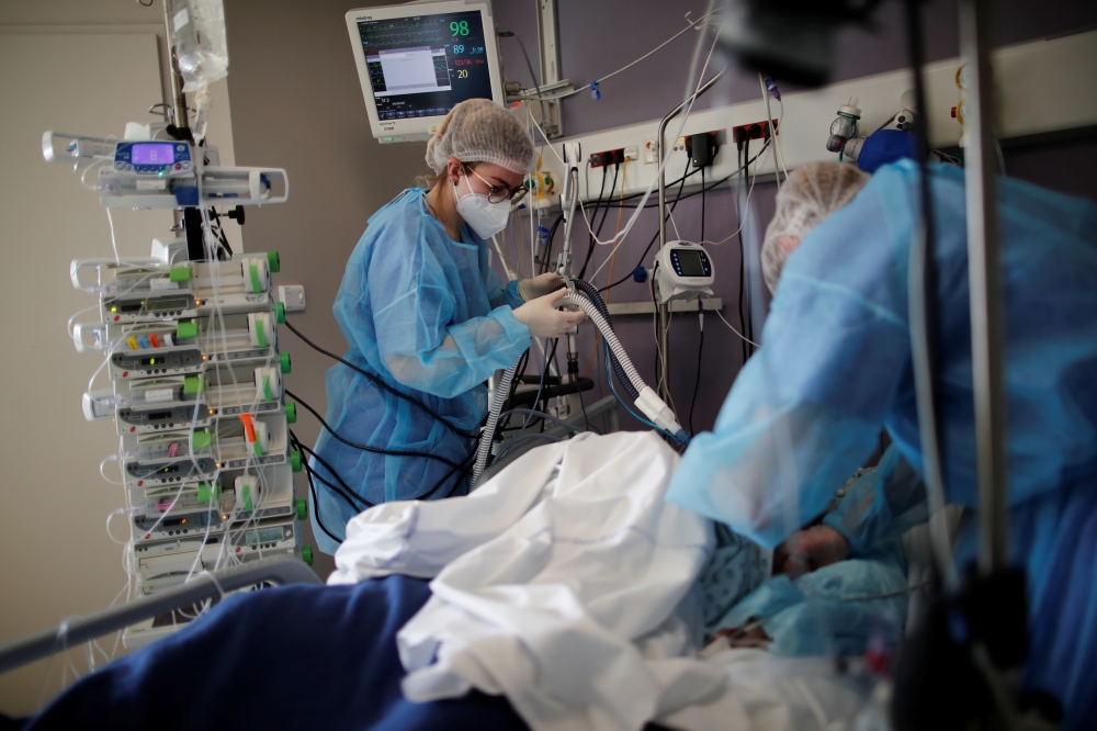 Medical staff members work in the Intensive Care Unit (ICU) where patients suffering from the coronavirus disease (COVID-19) are treated at the Melun-Senart hospital, near Paris, France, March 8, 2021. REUTERS/Benoit Tessier
