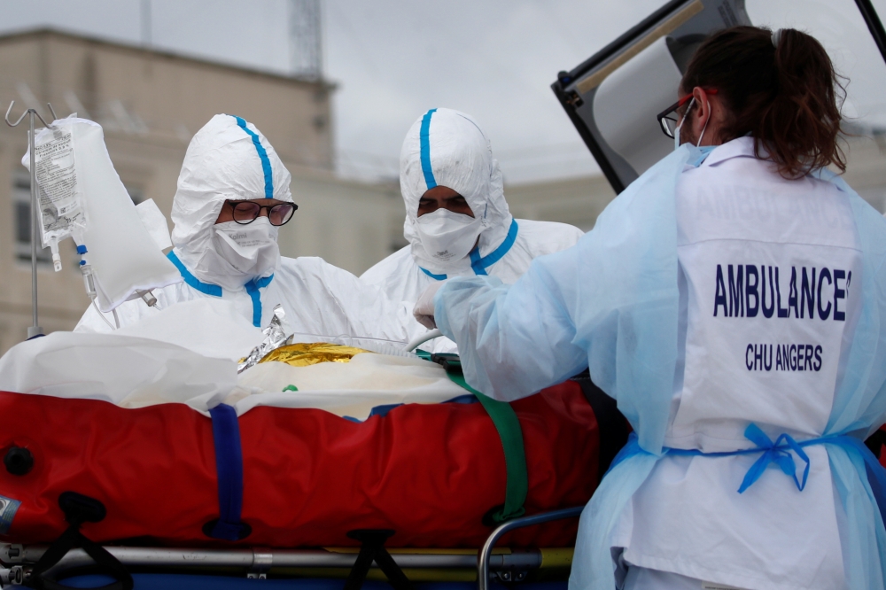 A medical crew from Angers hospital carries a patient suffering from the coronavirus disease (COVID-19) on a stretcher after his transfer by a helicopter of French SAMU rescue team, from the Ile de France region to Angers hospital, France, March 15, 2021.