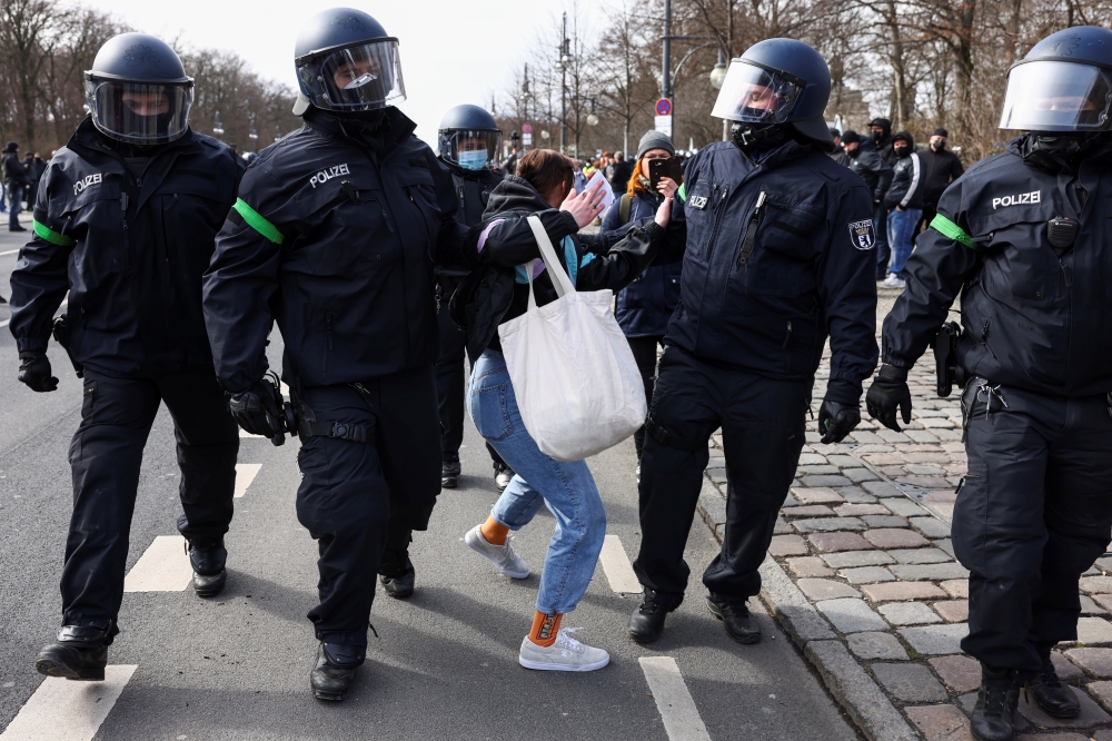 Police officers detain a demonstrator during a right-wing rally against the government's restrictions following the coronavirus disease (COVID-19) outbreak in Berlin, Germany, March 20, 2021. REUTERS/Christian Mang