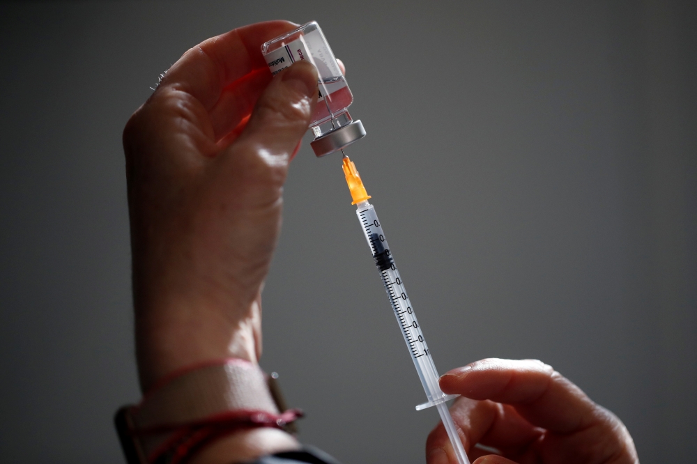 FILE PHOTO: A pharmacist prepares a dose of the AstraZeneca COVID-19 vaccine in a pharmacy in Paris as part of the coronavirus disease (COVID-19) vaccination campaign in France, March 19, 2021. REUTERS/Benoit Tessier