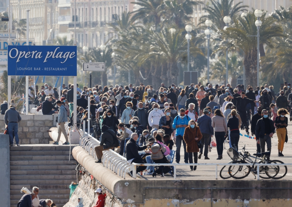 People enjoy a sunny and warm weather on the Promenade des Anglais during the third lockdown imposed to slow the rate of the coronavirus disease (COVID-19) contagion, in Nice, France, March 27, 2021. Reuters/ Eric Gaillard