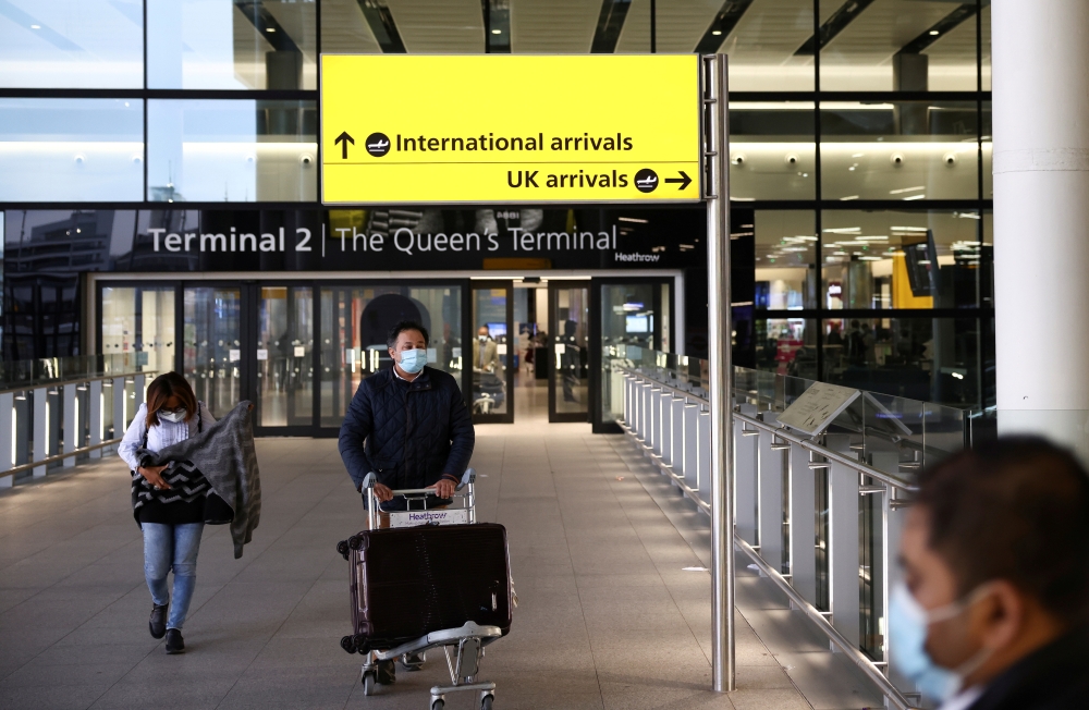 FILE PHOTO: Travellers walk through Terminal 2 at Heathrow Airport, amid the coronavirus disease (COVID-19) outbreak in London, Britain February 14, 2021. REUTERS/Henry Nicholls//File Photo
