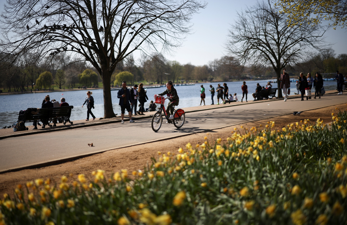 A person cycles through Hyde Park during sunny weather, amid the coronavirus disease (COVID-19) outbreak, in LONDON, Britain, April 4, 2021. REUTERS/Henry Nicholls
