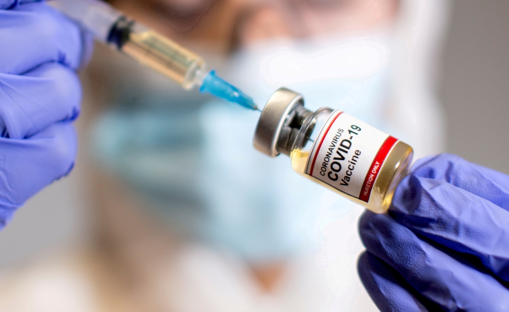  A woman holds a small bottle labelled with a 