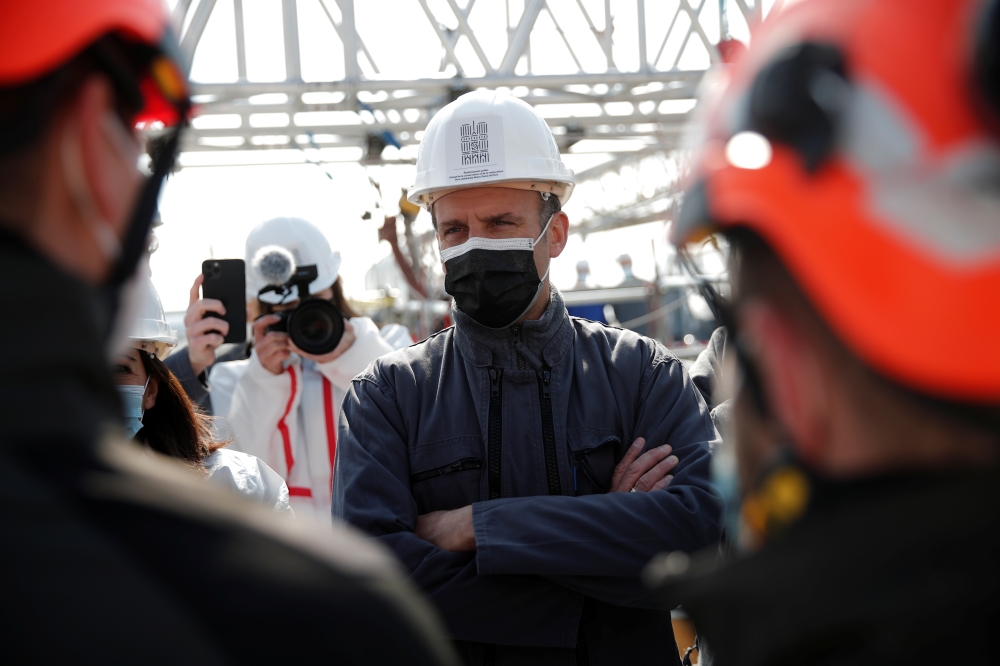 French President Emmanuel Macron talks with workers during a visit at the reconstruction site of the roof of the Notre-Dame de Paris Cathedral, which was damaged in a devastating fire two years ago, as restoration works continue, in Paris, France, April 1
