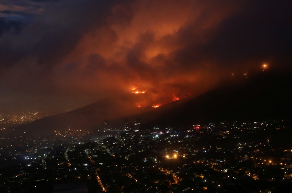 Flames are seen close to the city fanned by strong winds after a bushfire broke out on the slopes of Table Mountain in Cape Town, South Africa, on April 19, 2021. Reuters/Mike Hutchings