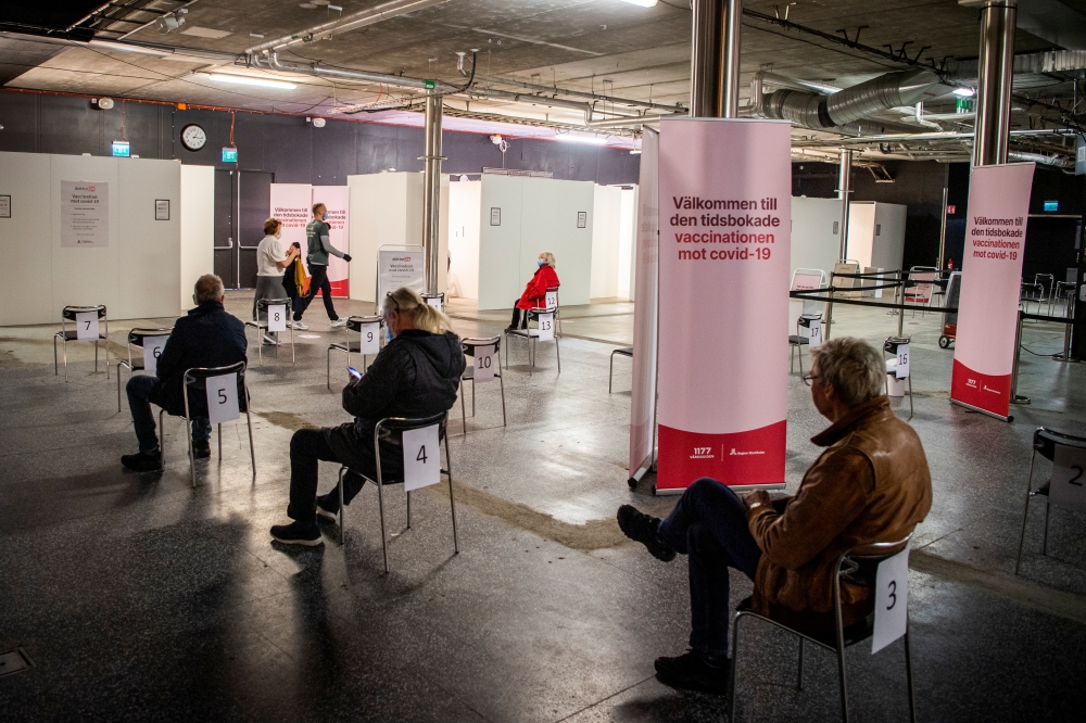 People wait to get a vaccine against the coronavirus disease (COVID-19) at a night club which was turned into a mass vaccination center, in Stockholm, Sweden, April 16, 2021. Carl-Olof Zimmerman/TT News Agency/via REUTERS