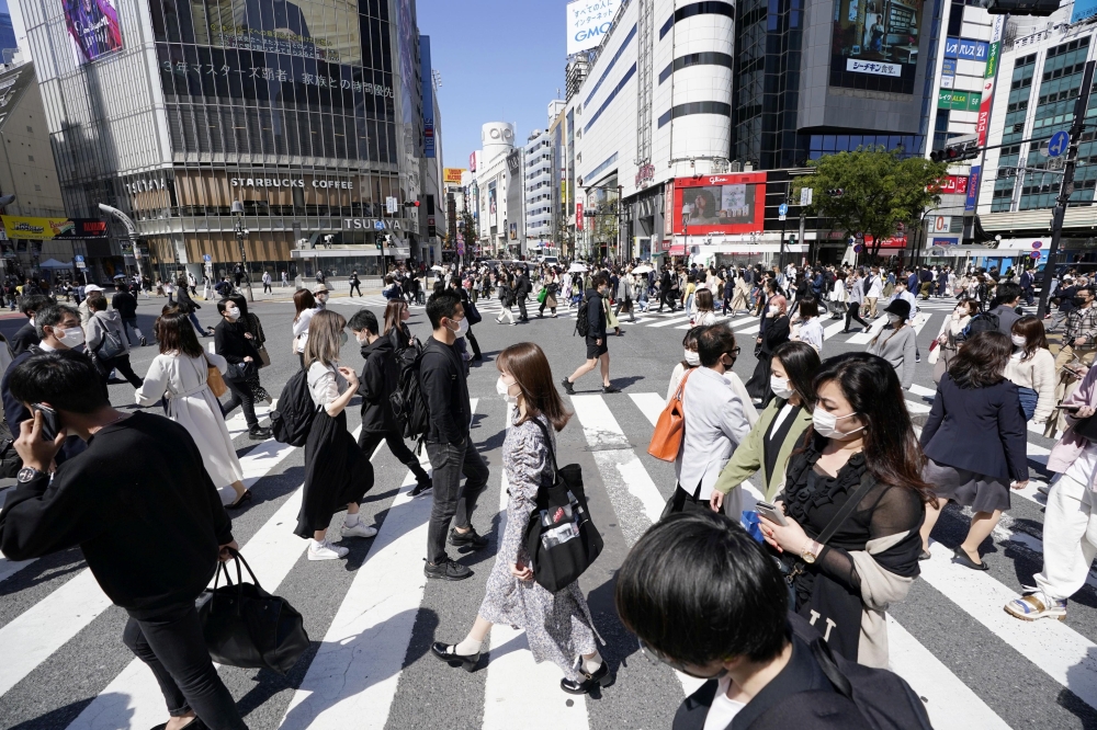 Passersby wearing protective face masks walk on Shibuya crossing amid the coronavirus disease (COVID-19) outbreak in Tokyo, Japan April 23, 2021, in this photo taken by Kyodo. Kyodo/via REUTERS