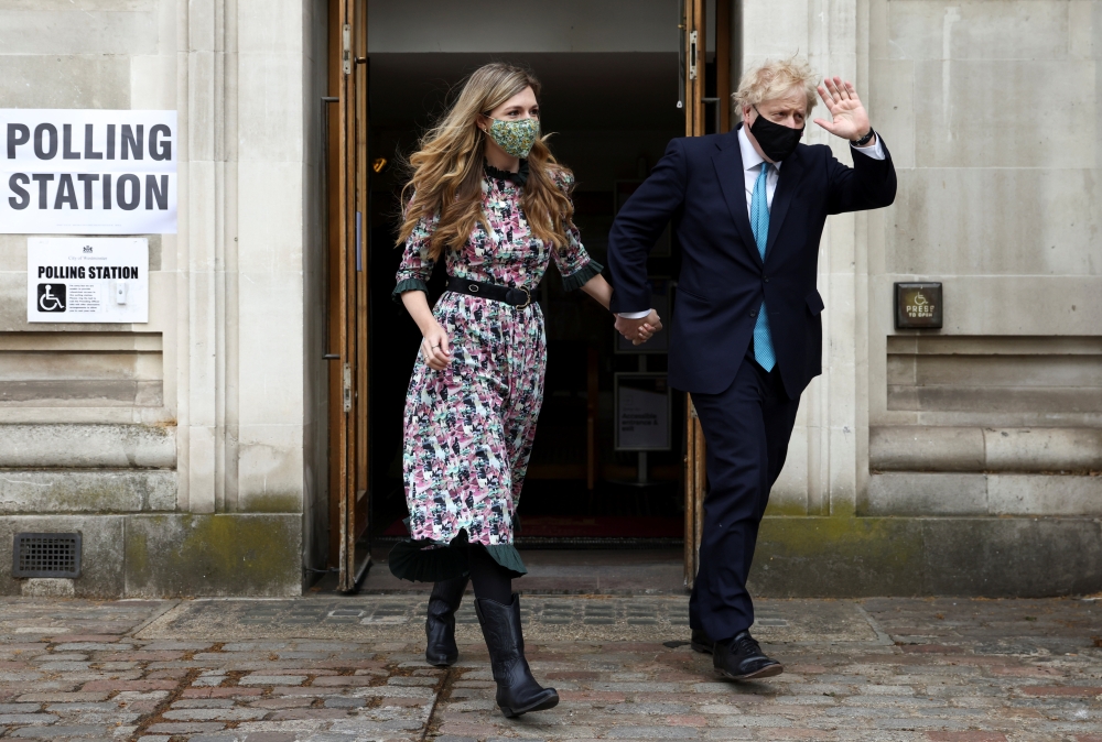 Britain's Prime Minister Boris Johnson and partner Carrie Symonds leave Westminster polling station after voting, in London, Britain May 6, 2021. REUTERS/Henry Nicholls