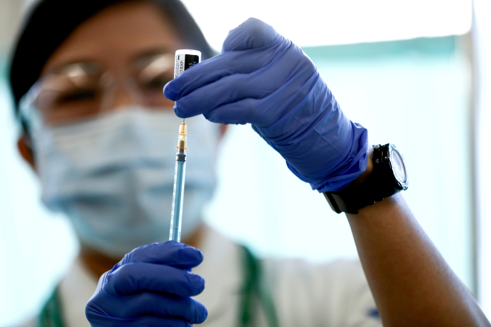FILE PHOTO: A medical worker fills a syringe with a dose of the Pfizer-BioNTech coronavirus disease (COVID-19) vaccine, at Tokyo Medical Center in Tokyo, Japan February 17, 2021. Behrouz Mehri/Pool via REUTERS