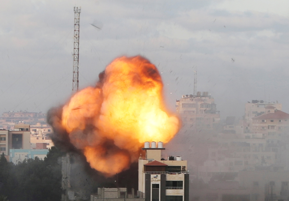 Smoke and flames are seen following an Israeli air strike on a building, amid a flare-up of Israeli-Palestinian fighting, in Gaza City May 18, 2021. REUTERS/Mohammed Salem