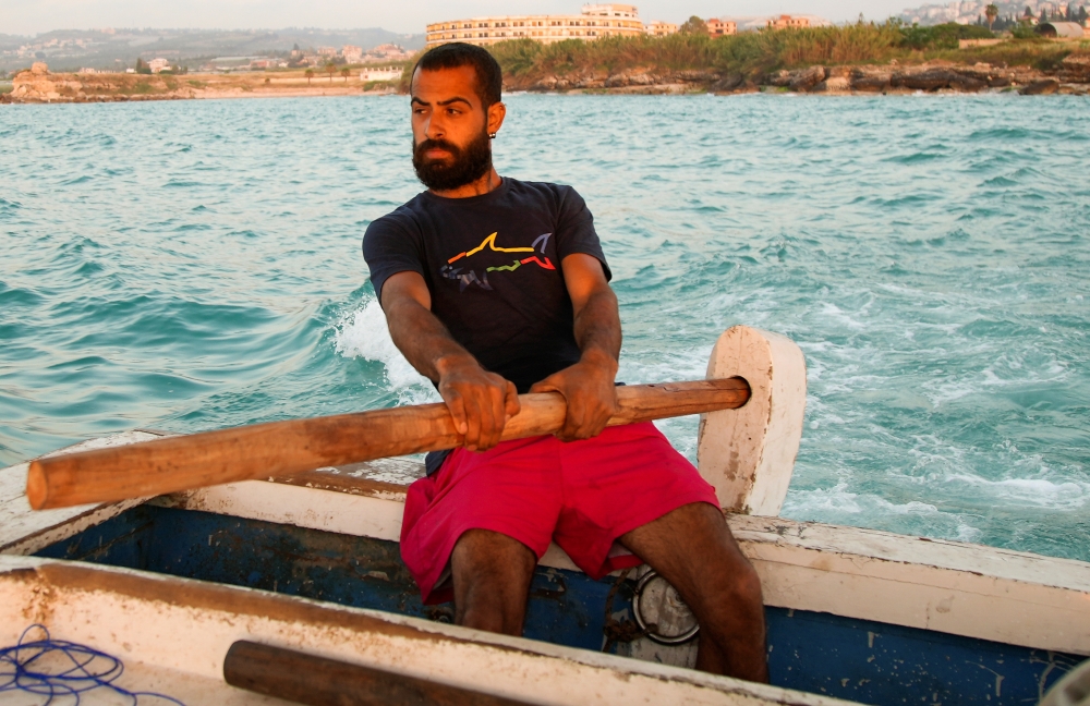 Ali Sleem, sits on a fishing boat in Sarafand, Lebanon May 10, 2021. Picture taken May 10, 2021. Reuters/Issam Abdallah
